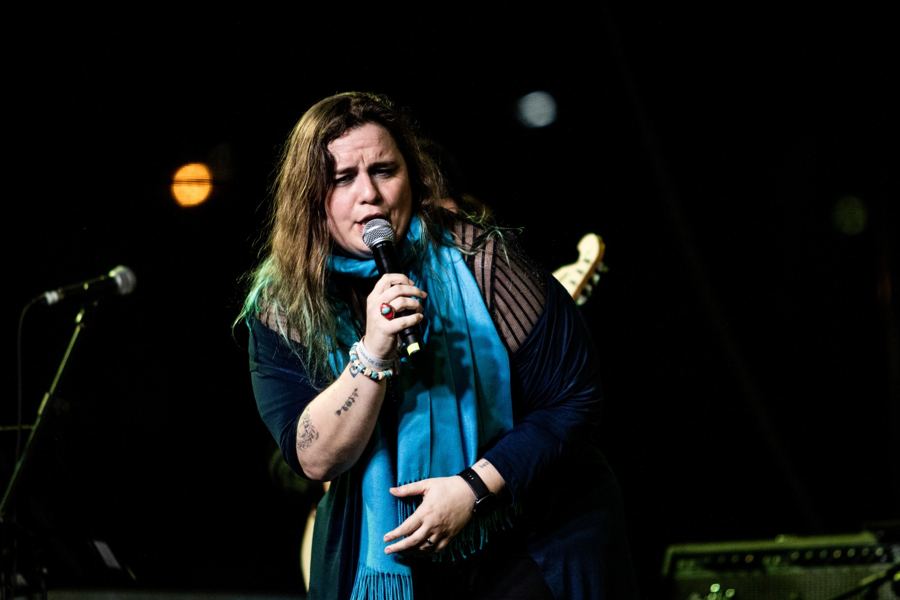 Letícia cantando com o microfone na mão