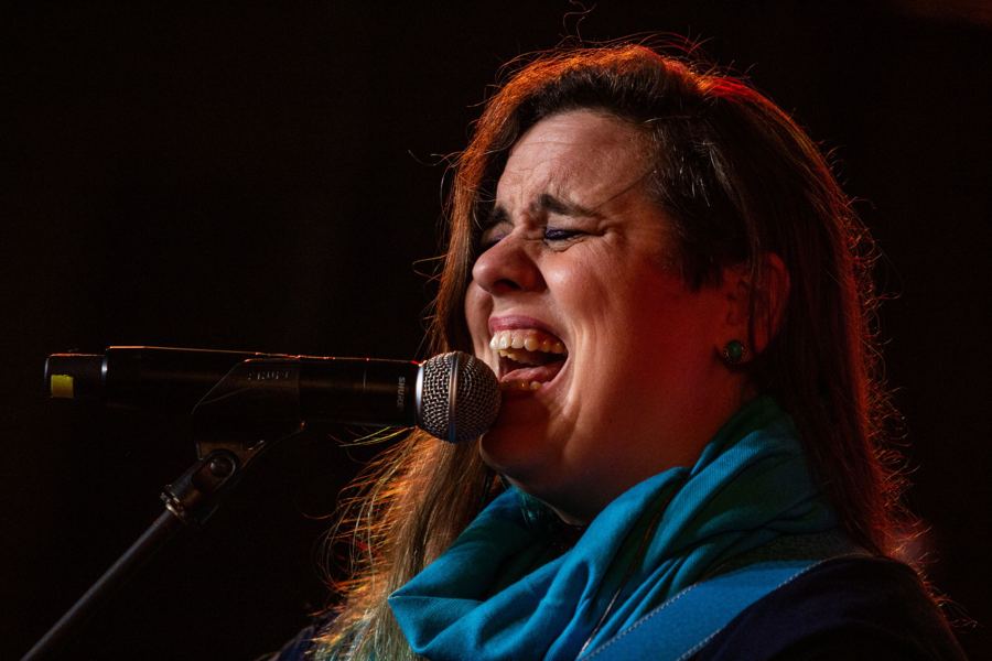 Letícia cantando no microfone de pedestal